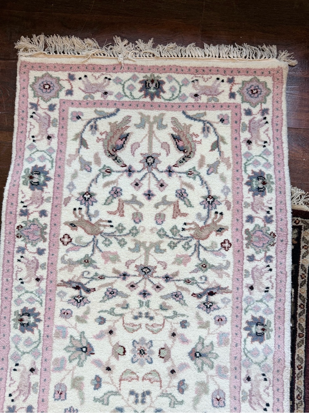 A hand-knotted Persian Runner rug measures 10 feet by 24 inches.